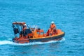 A orange rescue boat in the blue sea