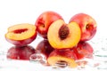 Peaches whole and cutted into two halves in water drops on white background isolated close up