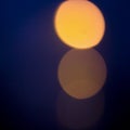 Bright orange round blurred moon or traffic lights on dark blue violet bokeh background Royalty Free Stock Photo