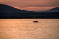 bright orange seascape at sunset, yacht on the background of the mountains of the resort city of Gelendzhik