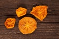 Bright orange slices of dried persimmon Hoshigaki on an old wooden board. Top view