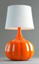 A bright orange table lamp featuring a pumpkin-shaped white shade. Royalty Free Stock Photo