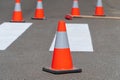 Bright orange traffic cones standing on asphalt. Painting road markings. Traffic cones for road works Royalty Free Stock Photo