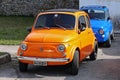 Bright orange vintage Fiat 500 with another blue one behind. Royalty Free Stock Photo