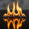 Flames rise and curve on a reflective black surface, creating a Royalty Free Stock Photo