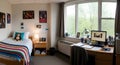 Bright and organized student dorm room interior featuring a study desk, personal computer, and comfortable bed Royalty Free Stock Photo
