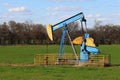 Bright painted old abandoned oil well derrick green meadow pasture