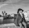 Happy modern girl in red coat on embankment in Paris, France Royalty Free Stock Photo