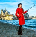 Smiling tourist woman in Paris taking selfie using selfie stick Royalty Free Stock Photo