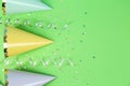 Bright party hats, serpentine streamers and confetti on green background, flat lay Royalty Free Stock Photo