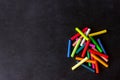 Bright pastel crayons lying on a black school board. Children`s creativity.