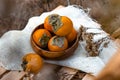 Bright persimmon fruits, orange fruits from the tree with a pleasant sweet and astringent taste among the dry twigs of the autumn