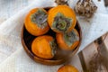 Bright persimmon fruits, orange fruits from the tree with a pleasant sweet and astringent taste among the dry twigs of the autumn