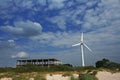 Bright picture of wind turbine standing near unfinished building.