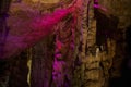 Bright pink abstract background of stalactites, stalagmites and stalagnates in a cave underground, horizontal