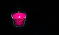 Bright pink candle in a glass jar on a black background. The candle is burning. Extinguished candle. Smoke from the candle. Hearth Royalty Free Stock Photo