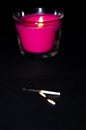 Bright pink candle in a glass jar on a black background. The candle is burning. Extinguished candle. Smoke from the candle. Hearth Royalty Free Stock Photo