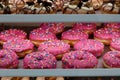 Bright pink doughnuts with multi coloured sugar sprinkles standing on shelf Royalty Free Stock Photo