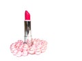 Bright pink open lipstick in a silver case and pink pearl beads isolated on a white background Royalty Free Stock Photo