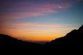 Bright pink-orange sunset sky on a black silhouette of mountains Royalty Free Stock Photo