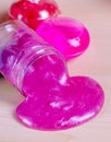 Bright pink slime spilling of from the bottle. Elastic glue with glitter worldwide popular kids toy