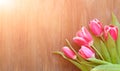 Bright pink tulips on natural wooden background, with the spray of the water, in honor of women`s day