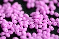 Bright pink twin beads scattered on a dark surface