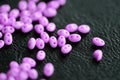 Bright pink twin beads scattered on a dark surface