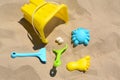 Bright plastic bucket, rake and shovel on sand. Beach toys Royalty Free Stock Photo