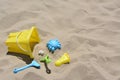 Bright plastic bucket, rake and shovel on sand. Beach toys. Space for text Royalty Free Stock Photo