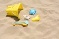 Bright plastic bucket and rakes on sand. Beach toys. Space for text
