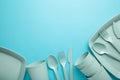 Bright plastic reusable tableware on a blue background