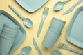 Bright plastic reusable tableware on a yelow background