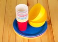 Bright plastic tableware on background of light wood. Royalty Free Stock Photo