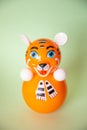 Bright plastic toy-tumbler as tiger on green background