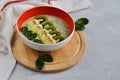 Bright plate with a healthy Breakfast power bowl made of natural yogurt, Chia seeds, banana, kiwi, celery and spinach on a gray