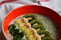 Bright plate with a healthy Breakfast power bowl made of natural yogurt, Chia seeds, banana, kiwi, celery and spinach on