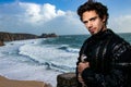 Bright portrait of handsome knight standing on castle balcony with blue skies and ocean in background Royalty Free Stock Photo