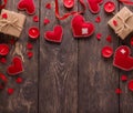 Bright postcard for Valentine`s day. Scarlet hearts, ribbon and candles on wooden table