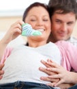 Bright pregnant woman holding baby shoes at home Royalty Free Stock Photo