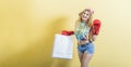 A young girl shopper in boxing gloves holds shopping bags in her hand and is ready for a sale. Royalty Free Stock Photo