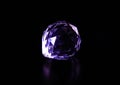 Bright purple gemstone on a dark background, radiating sparkles of light and color