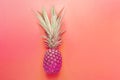 Bright purple neon color pineapple on gradient pink coral background. Long bushy green leaves. Summer vacation travel tropical