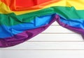 Bright rainbow gay flag on wooden background with space for text. LGBT community