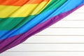 Bright rainbow gay flag on wooden background, with space for text. LGBT community