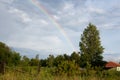 Bright rainbow in the summer over the apple orchard Royalty Free Stock Photo