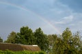 Bright rainbow in the summer over the apple orchard Royalty Free Stock Photo