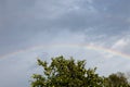 Bright rainbow in the summer over the apple orchard Royalty Free Stock Photo