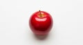 A bright red apple rests against a plain white background. It Royalty Free Stock Photo