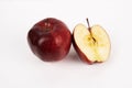Bright red apple stands whole beside a half section showcasing fresh, raw fruit texture Royalty Free Stock Photo